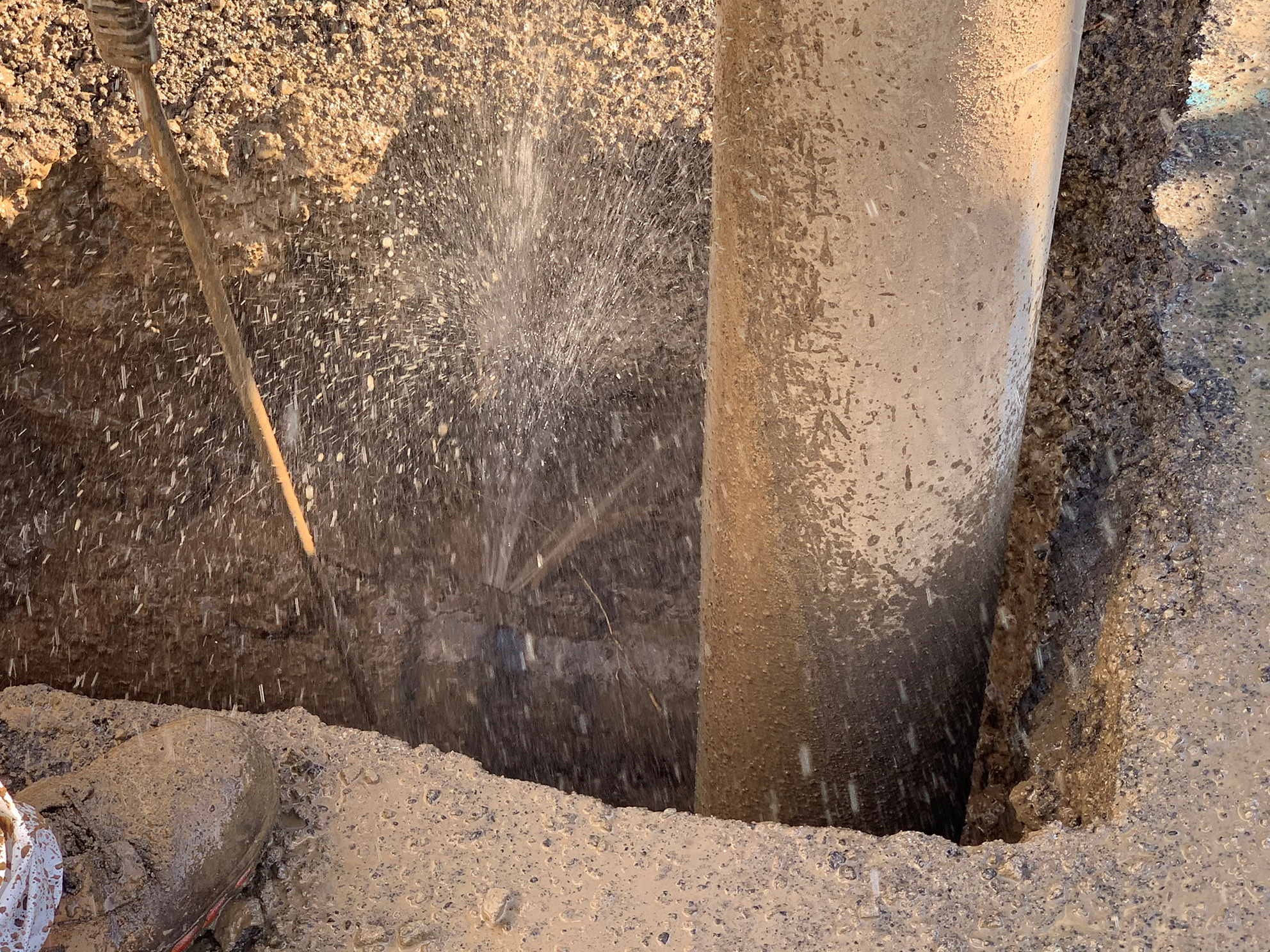 a leak in an underground pipe that is spraying water