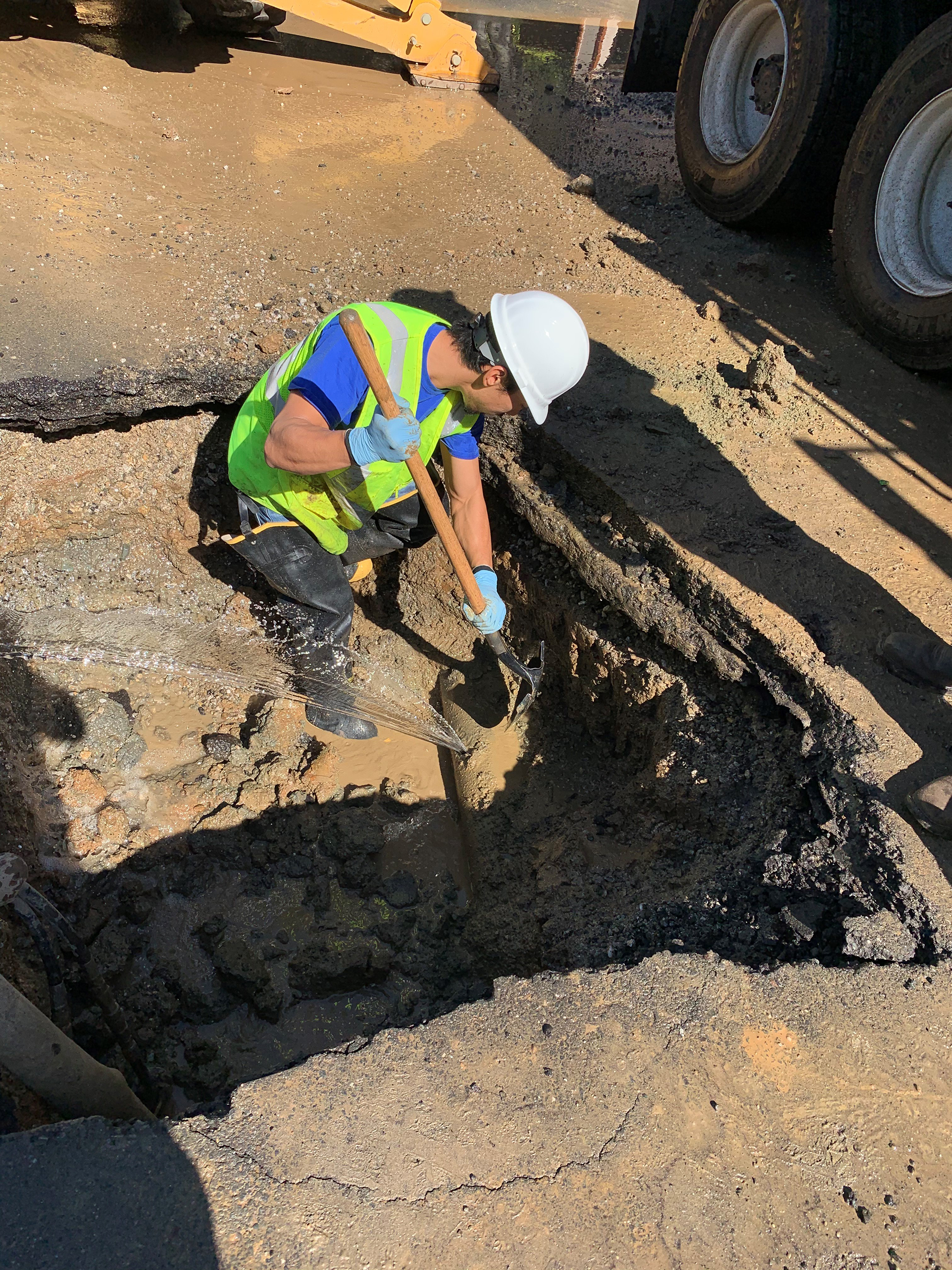 an employee working on an underground leak in a pipe