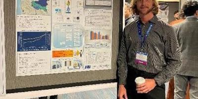 Ethan Smith standing in front of poster