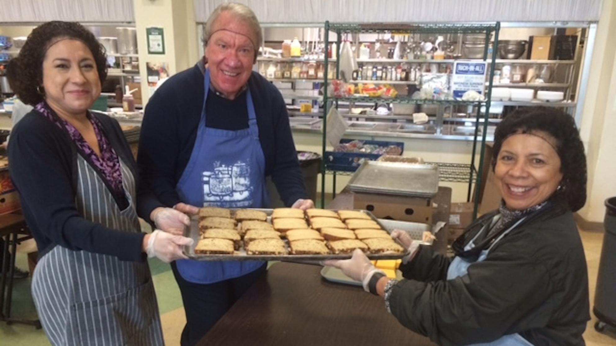 Employees in Martha's Kitchen with tray of sandwiches