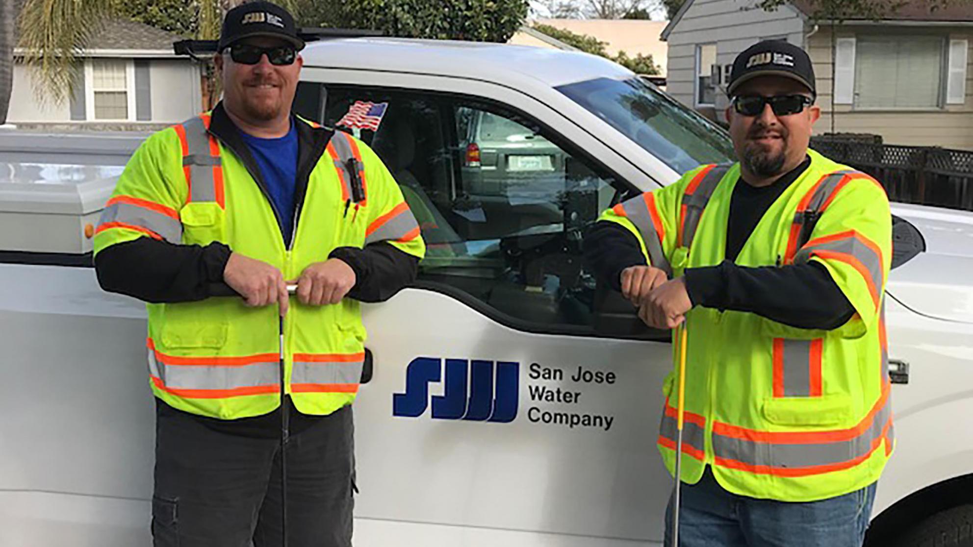 Two SJW employees standing in front of a work truck 