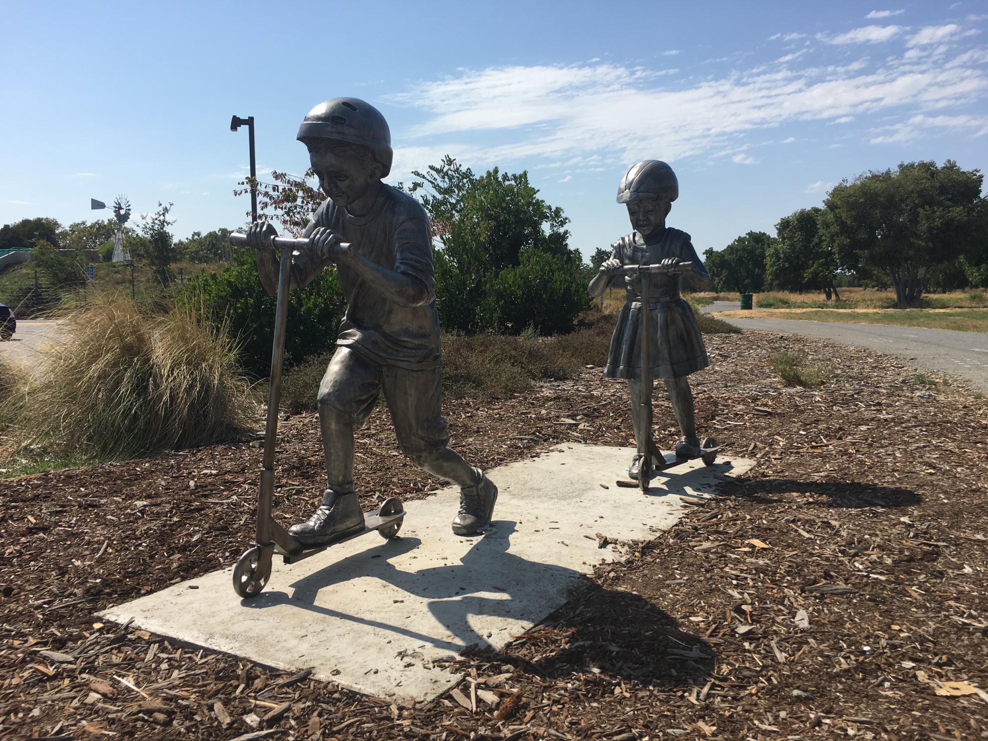 Children's Rotary Sculpture Walk Statues - Children on Scooters