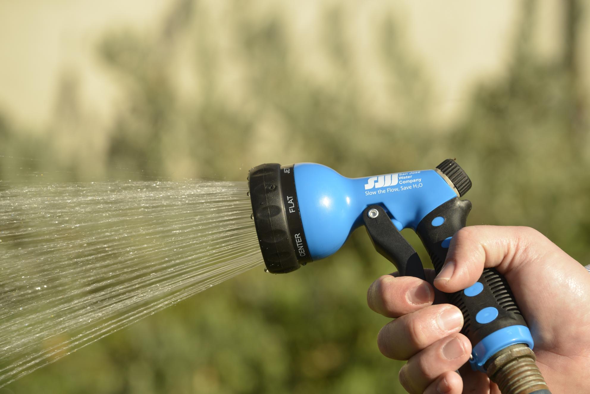Hand holding San Jose Water-branded garden hose