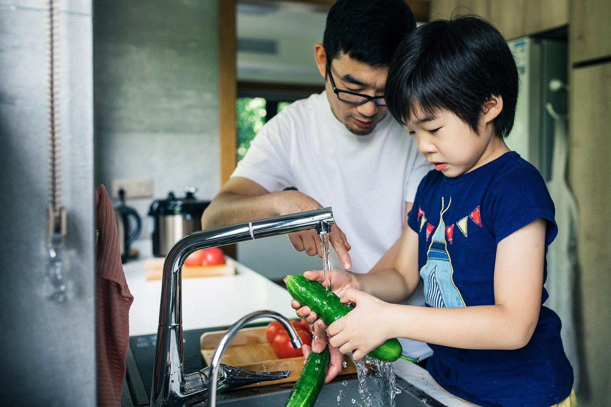 Father and daughter washing vegetables