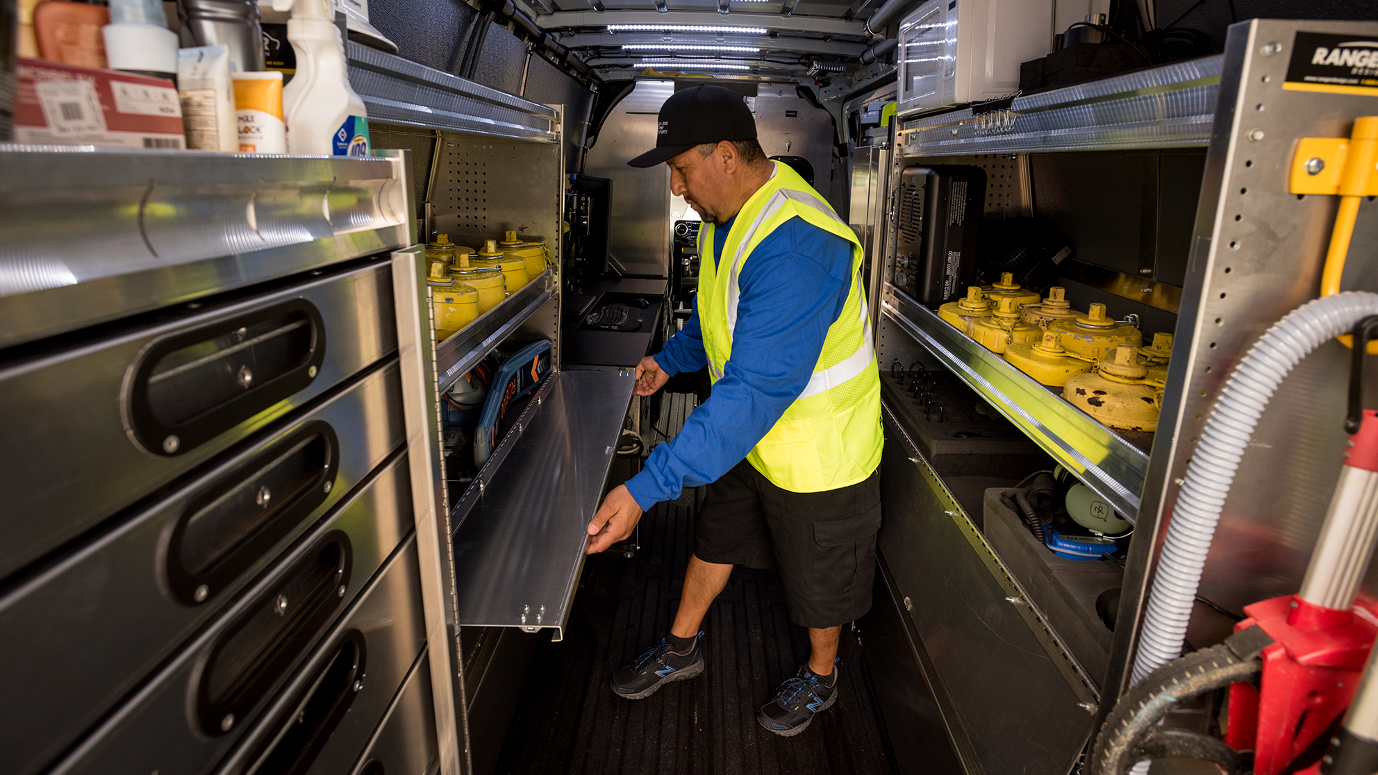 San Jose Water employee looking through the back of his organized truck.