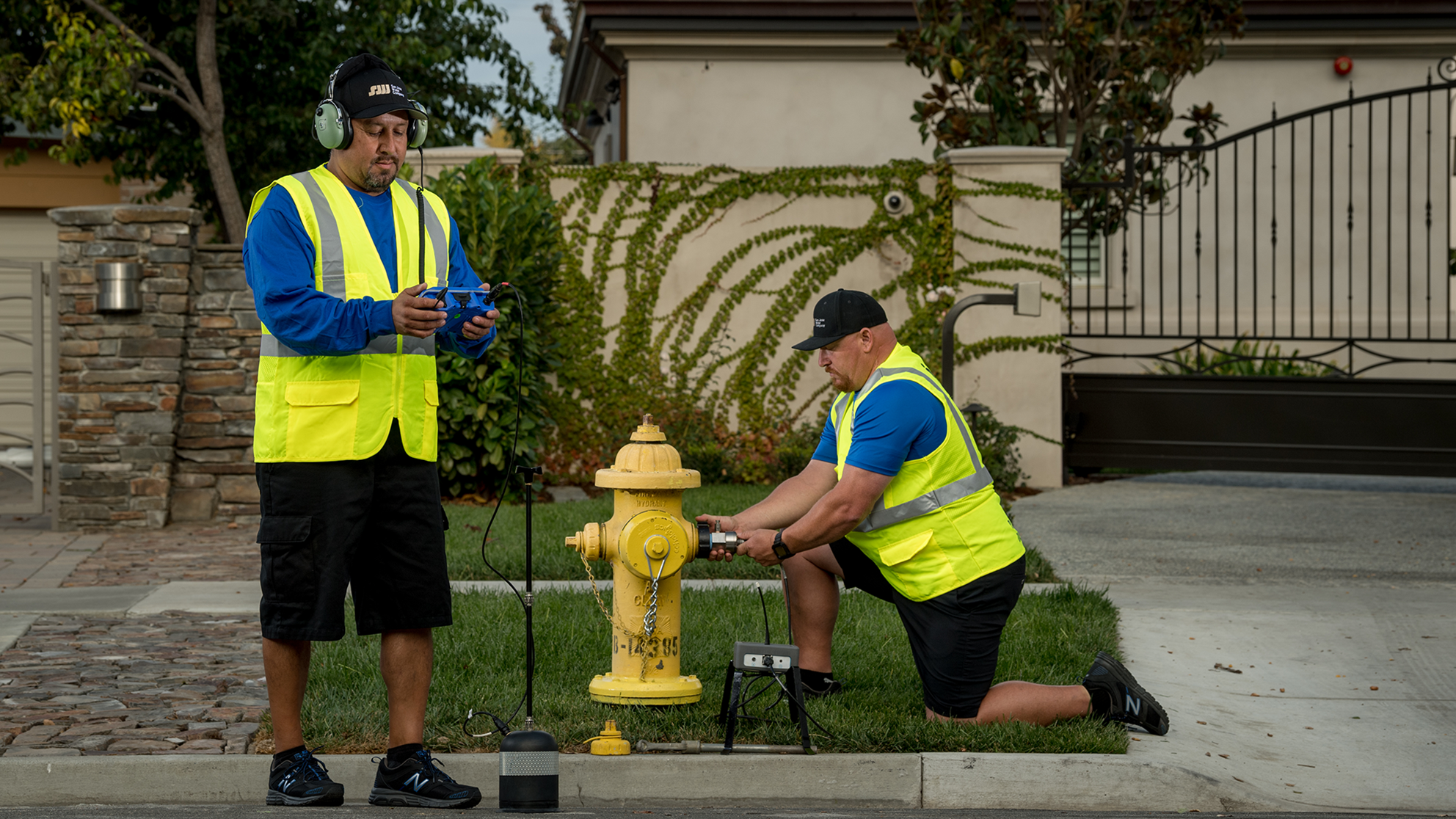 Two male San Jose Water employees checking a residential fire hydrant 