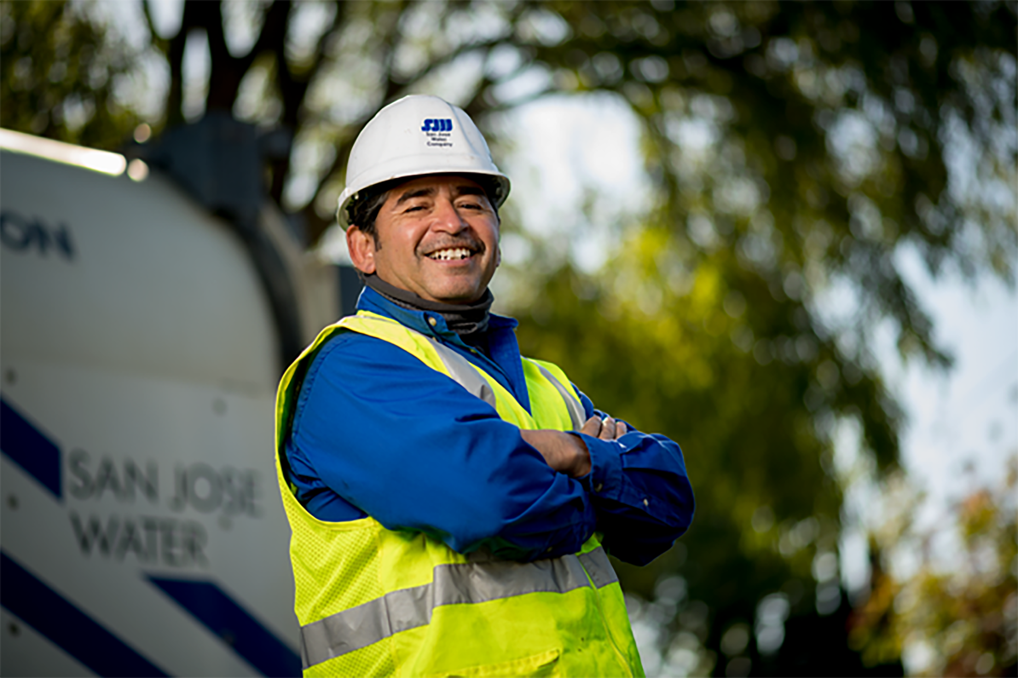 SJW-field-worker.png A male San Jose Water employee smiling with his arms cross in front of work truck.