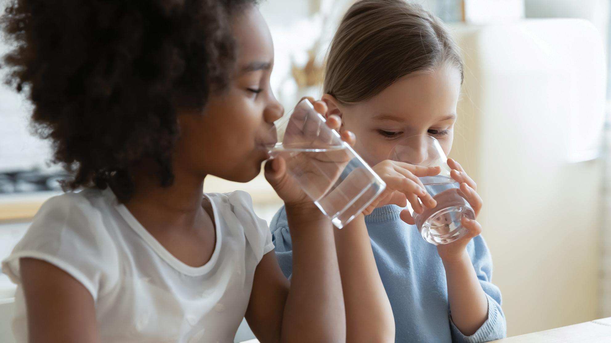 Children drinking water from glasses