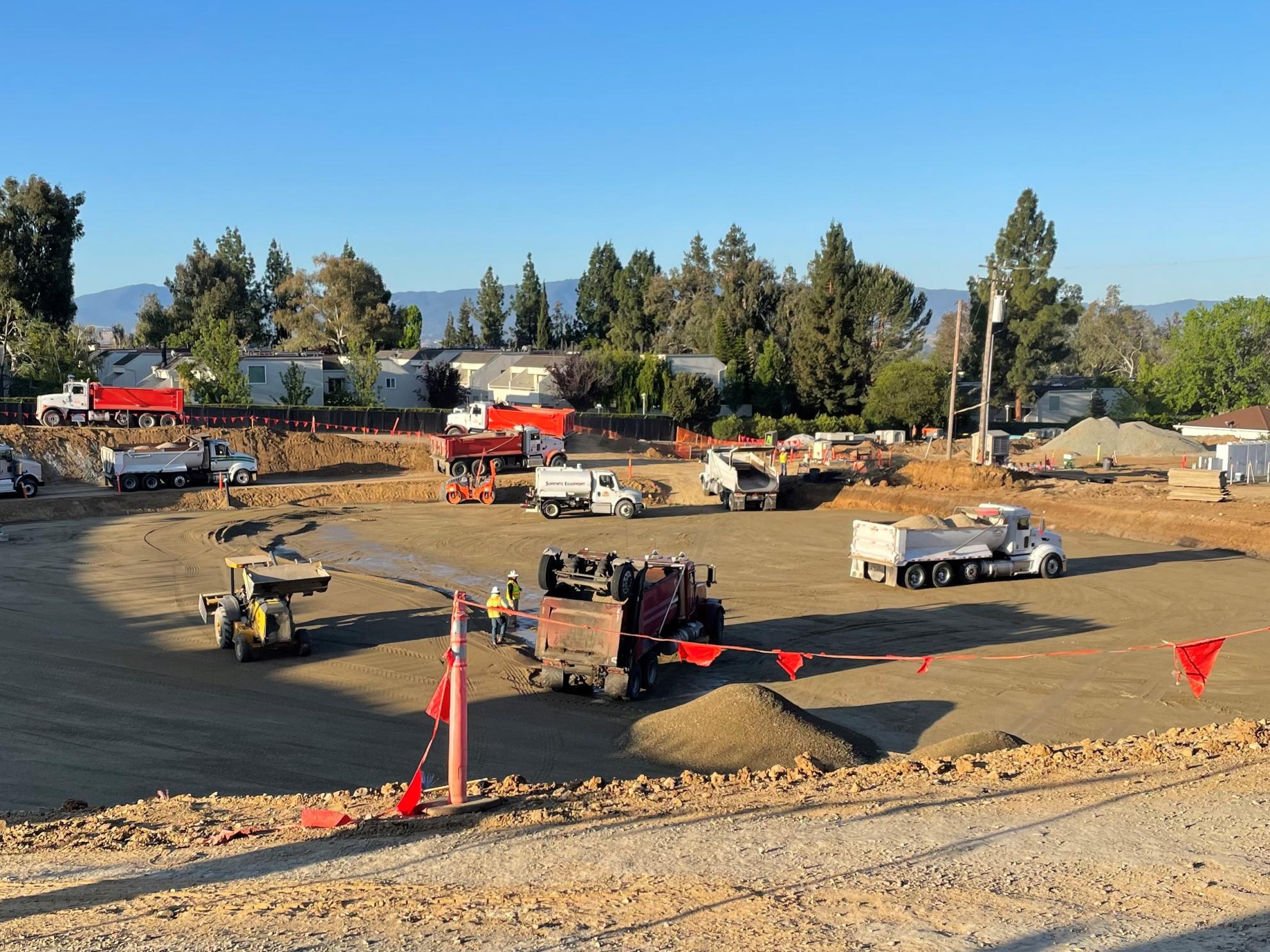 Heavy equipment removing excess soil from base of new tank