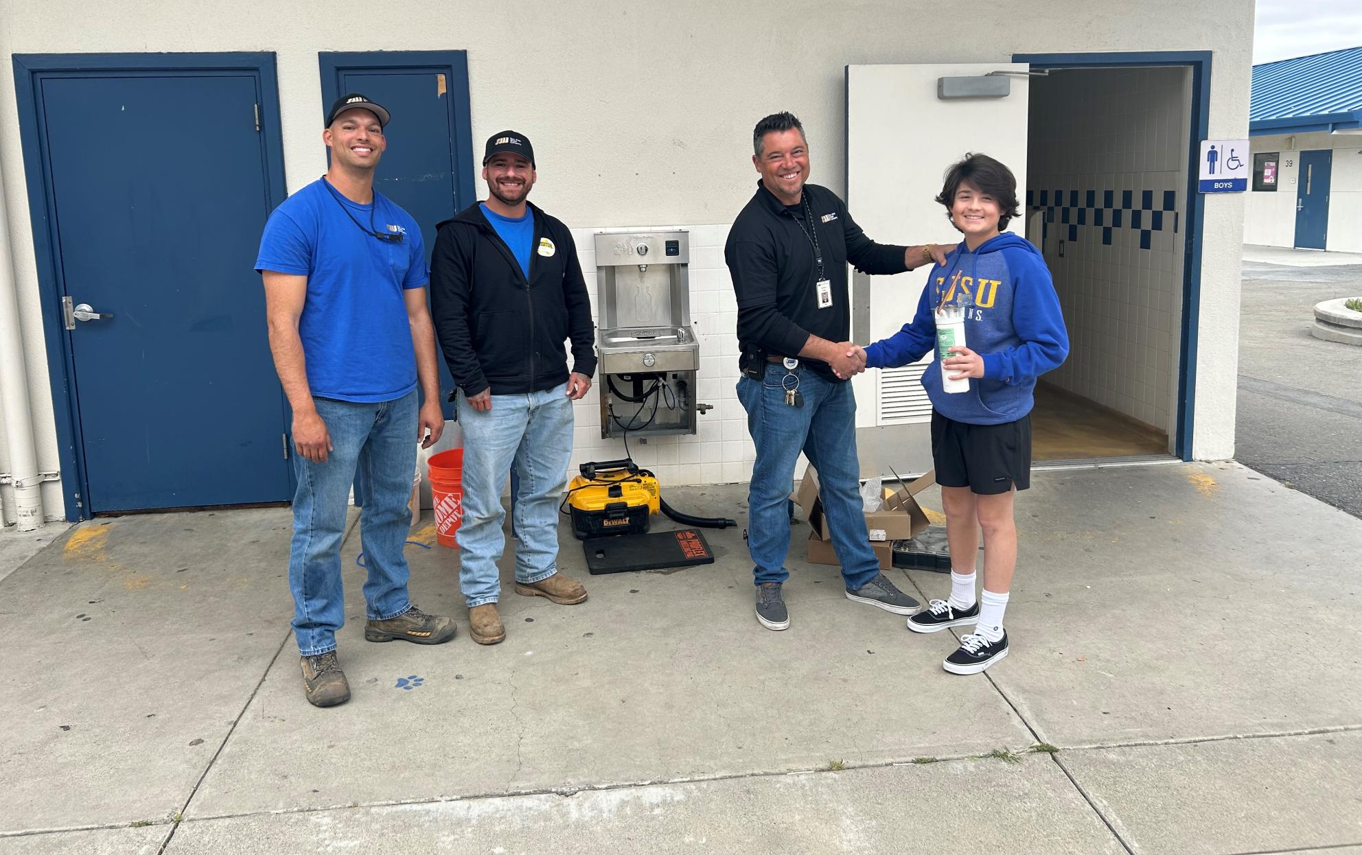 Richard Tapia with son and crew by fountain install at Ida Price Middle School