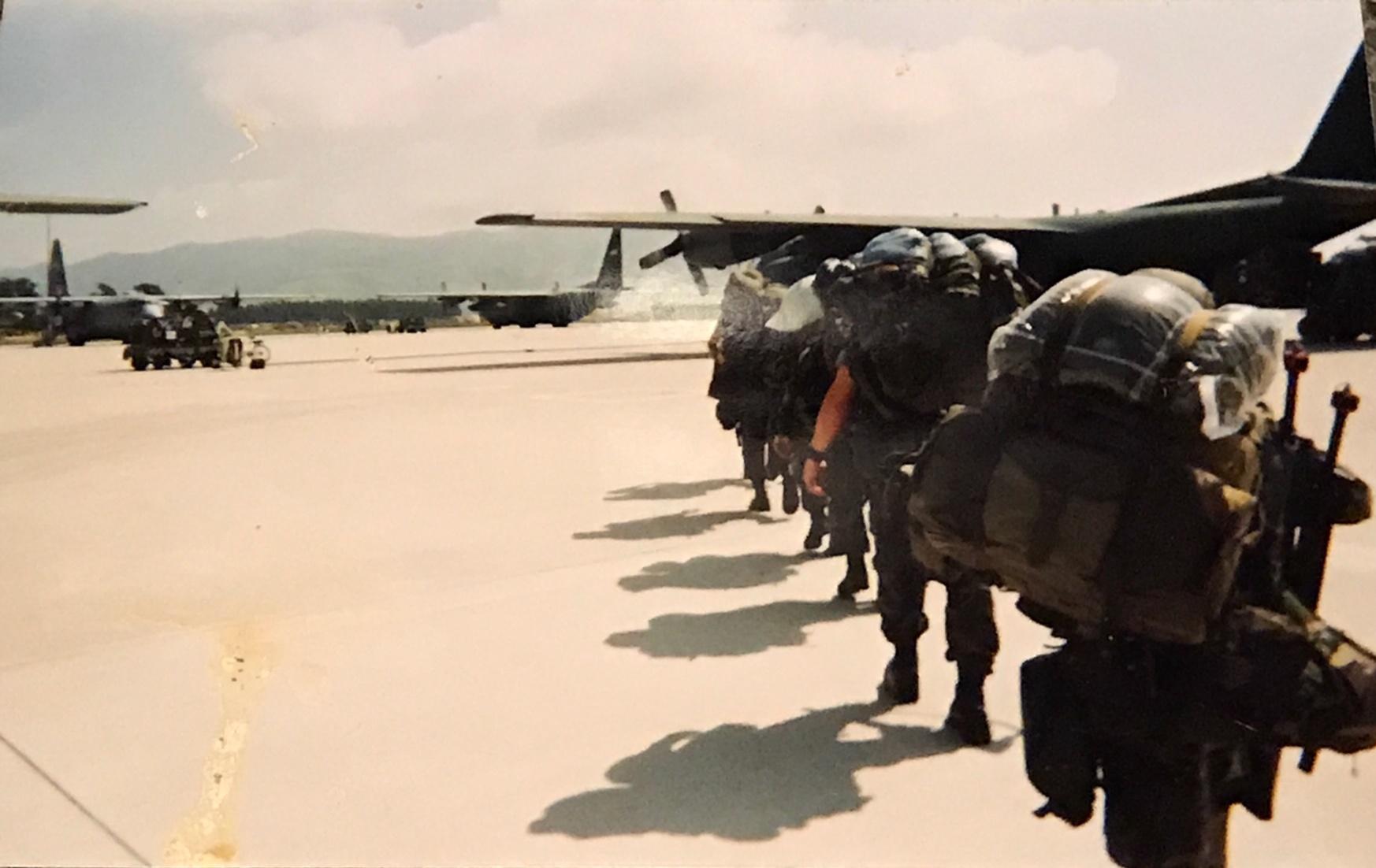 Air force soldiers on the tarmac walking towards a large military plane
