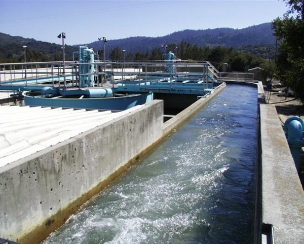 Water rushing along an outdoor concrete channel at a water treatment plant